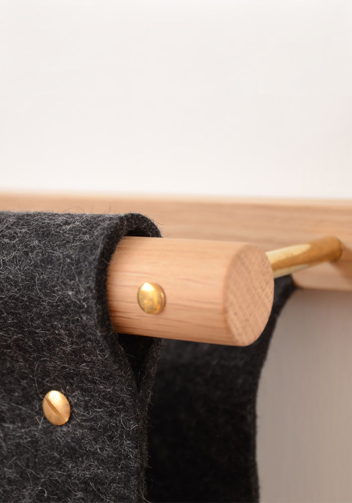 Wall mounted magazine rack and mail holder made from oak, brass and black felt.